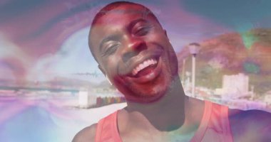 Kablosuz kulaklık takan adam deniz kıyısında el sallıyor, yüzen haritalarla teknoloji teması gösteriyor. Rahat, rahat, hayat dolu, yaşam tarzı, kentsel, manzaralı, sağlıklı.