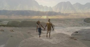 Çıplak ayakla el ele tutuşan çift, kum üzerinde yuvarlanan dalgalar ve kayalarla, sağlık grafiğini gösteriyor. Romantizm, bağlantı, dinginlik, macera, doğa, uyum, rahatlama