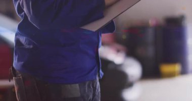 Garajda ışık sızıntısı ve yüzen veri tabloları olan notlar yazan kadın teknisyen. Endüstriyel, hassas, profesyonel, mekanik, teftiş, kalibrasyon, iş akışı