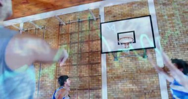 Spor salonunda mavi-beyaz formalar giyen genç basketbol takımı hareket yolları olan çemberin altına atlıyor. Eylem, takım çalışması, atlet, fitness, yarışma, spor giyim, kentsel