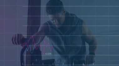 Adam spor salonunda ağır torba yumrukluyor, hareket halindeki mali tabloları ve yüzdelik grafikleri var. Spor, eğitim, güç, çeviklik, kararlılık, odaklanma, motivasyon