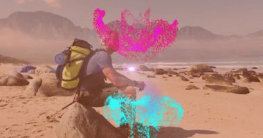 Olgun yürüyüşçü sahilde seyahat reklamı yapıyor. Pembe turkuaz parçacıkları aydınlatan mercekler. Macera, keşif, vahşi doğa, sükunet, manzara, dayanıklılık, açık hava