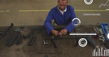 Fabrika bankında metal çerçeve monte eden mavi iş ceketi giyen adam dijital veri örtülerini gösteriyor. Sanayi, zanaat, teknoloji, üretim, kesinlik, atölye, mühendislik