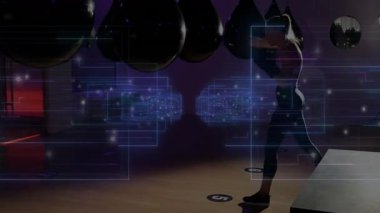 Kadın boksör loş spor salonunda hareketlerini çalışıyor, yüzen teknoloji şebekesi ve veri örtüsüyle. Sporcu, antrenman, fütürist, minimalist, yüksek teknoloji, kararlılık, fitness