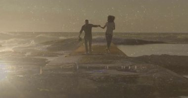 Günbatımında iskelede el ele tutuşan çift, animasyon çizelgesi ve kalp ikonu teknolojiyi gösteriyor. Romantik, dinginlik, günbatımı, siluet, okyanus, boş zaman, seyahat