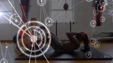 Antrenör ve stajyer fitness stüdyosunda HUD kaplamalı, kum torbalarıyla mekik çekiyorlar. Egzersiz, eğitim, fitness, sağlık, spor salonu, güç, sağlık