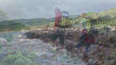 Kayalık sahil kıyılarında yürüyüş yapan erkek ve kadın, sağlık çubukları ve patika haritalarını gösteriyor. Macera, keşif, manzara, engebeli, açık hava, doğa, dayanıklılık.