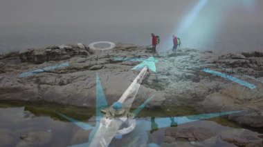 Evet ve ok olmadığını gösteren hareketli navigasyon pusulası kullanarak engebeli kıyı şeridi yürüyüşü yapan çift. Macera, keşif, seyrüsefer, açık hava, vahşi doğa, yolculuk, keşif