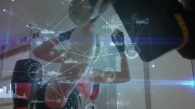 Spor salonunda kadın kum torbasını yumrukluyor fitness teknolojisi için dijital arayüz grafikleri sergiliyor. Fitness, atletizm, yüksek teknoloji, eğitim, yenilik, modernleşme, güç