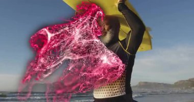 Kumsalda sarı sörf tahtası tutan olgun bir sörfçü, etrafında dönen pembe parçacıklar olan sağlık çizelgesini gösteriyor. Macera, canlılık, dinamik, doğal, enerjik, açık hava, canlı