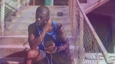 Kulaklığı beton basamaklara ayarlayan adam animasyon akıllı telefon verileri ve fitness grafikleri gösteriyor. Atletik, kentsel, minimalist, sağlık, aktivite, fitness, açık hava