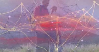 Parlak teknoloji ağ hatları ve veri izleriyle dağ yamacında gezinen çift. Macera, keşif, bağlantı, teknoloji, navigasyon, engebeli, açık hava