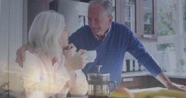 Kıdemli adam mutfakta yüzen sağlık ikonları ve kahve grafikleriyle olgun bir kadına el kaldırıyor. Sıcaklık, dostluk, sükunet, evcil, yaşam tarzı, kırsal, sağIık