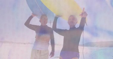 Güneşli sahilde yürüyen, sörf tahtaları taşıyan, hareketli seyahat rotaları gösteren bir çift. Macera, eğlence, eğlence, spor, açık hava, minimalist, enerjik