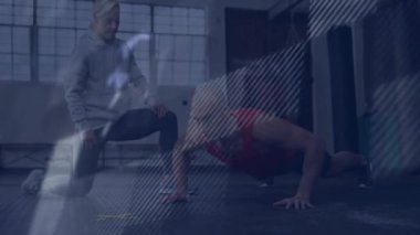 Spor salonunda şınav çeken bir adam, koç yanında diz çöküp animasyon kalp ikonu gösteriyor. Güç, fitness, antrenman, egzersiz, motivasyon, sağlık, dayanıklılık