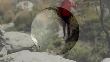 Yürüyüşçü, teknoloji kavramını gösteren dijital küre altında sırt çantasıyla Cairn 'in yanından geçiyor. Macera, keşif, seyrüsefer, açık hava, vahşi doğa, keşif, fitness