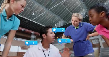 Spor sahasında genç oyunculara rehberlik eden erkek koç, yüzen sosyal tepki simgeleri gösteriyor. Danışman, takım çalışması, eğitim, dijital, eğitim, gençlik, motivasyon