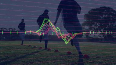 Spor analitik dalga formu ve şamdanlar sergileyen saha konileri arasında koşan futbol takım arkadaşları. Atletizm, spor, antrenman, fitness, açık hava, performans, takım çalışması