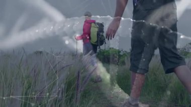 Olgun yürüyüşçüler, parlayan düğümlerle örülmüş teknoloji ağını göstererek, alan yolunda ilerliyorlar. Macera, açık hava, keşif, teknoloji, bağlantı, canlılık, manzara