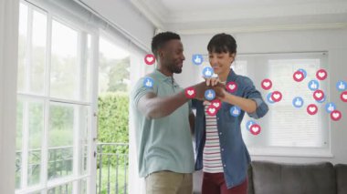 Modern salonda dans eden çift, dijital pazarlamayı yöneten yüzen sosyal medya ikonları. Kutlama, mutluluk, neşe, bağlantı, çağdaş, yaşam tarzı, sosyal medya