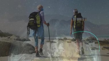 Erkek ve kadın gece Starry Plajı 'nda yürüyüş yaparken sırt çantaları ve direklerle canlandırılmış sağlık simgeleriyle. Macera, keşif, açık hava, dinginlik, turizm, engebeli doğa.