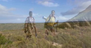 İki yürüyüşçü sırık ve sırt çantalarıyla yokuş yukarı tırmanıyor ve hareketli iş haritalarını sergiliyorlar. Macera, keşif, doğa, açık hava, canlılık, dayanıklı, yürüyüş