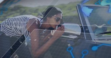 Yol kenarındaki üstü açılır yan aynaya yaslanan bir kadın hologram simgeleriyle teknoloji ızgaralarını gösteriyor. Gelecekçi, otomotiv, teknoloji, manzara, açık hava, tarz, yenilik