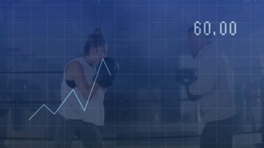 Boks salonundaki antrenör eldivenlerine yumruk atan kadın boksör, sağlık verilerinin üst üste bindiğini gösteriyor. Atletik, antrenman, fitness, modern, motivasyon, başarı, performans