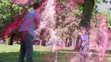 Futbol topu tutan adam ve parkta el ele tutuşan çocuk, spor pazarlaması için toz etkisi gösteriyor. Açık hava, aile, canlı, dinamik, eğlence, doğa, bağlantı