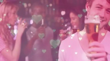 Adam loş barda bardaktan yudumluyor, kalp şeklinde bokeh kaplamaları ve pazarlama için neon tabelaları var. Romantik, gece hayatı, sosyalleşme, konforlu, hareketli, rahat, ambiyans