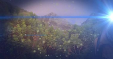 Gezici pazarlama için dağda yürüyüş yapan bir adam, yüzen ışık parçacıkları ile birlikte. Macera, açık hava, keşif, doğa, dayanıklılık, canlılık, yürüyüş