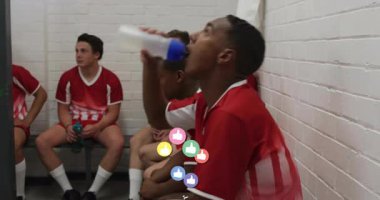 Bir grup futbolcu bankta dinleniyor ve yüzen başparmaklar spor markalarını destekliyor. Sporcular, takım çalışması, yoldaşlık, fitness, motivasyon, stadyum, yarışma