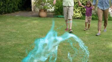 Dedem ve babam çimlerde sallanan çocuk, dijital parçacık girdabıyla teknolojiyi resmediyorlar. Aile, çoklu nesil, birlik, açık hava, eğlence, canlılık, doğa.