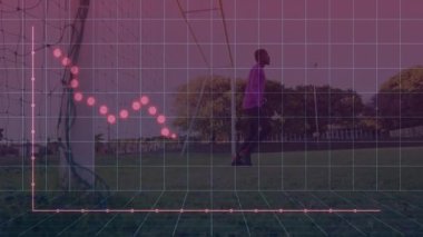 Genç kaleci, futbol sahasında çömelmiş, spor analitik şebekesini ve kırmızı veri hattını gösteriyor. Atletizm, spor, dijital, simülasyon, açık hava, kararlılık, yenilik