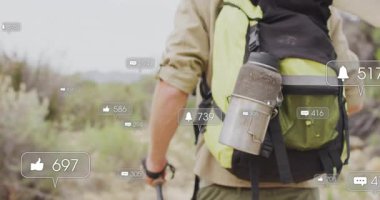 Kayalık patikada gezinen erkek yürüyüşçü, yüzen bildirim simgeleriyle dijital pazarlama sergiliyor. Macera, keşif, açık hava, engebeli, manzara, yolculuk, vahşi yaşam.