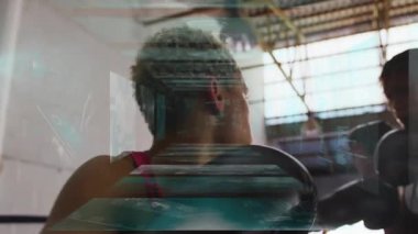 Spor salonunda boks ringlerine yaslanan iki bayan sporcu, yüzen spor verilerini gösteriyorlar. Sporcular, fitness, futuristik, teknoloji, eğitim, rekabet, güç