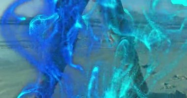 Kıdemli kadın kıyı boyunca yürürken mavi parçacıklar holografik teknoloji gibi dönüyorlar. Soyut, gelecekçilik, teknoloji, okyanus, dinginlik, refah, dijital