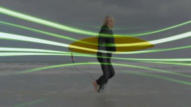 Sarı sörf tahtası taşıyan yaşlı bir kadın sörf yaparken teknoloji veri çizgilerini gösteriyor. Macera, açık hava, keşif, aktif, esneklik, minimalist, enerjik