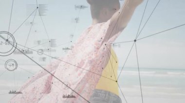 Sahilde kollarını açmış, dijital ağ grafiklerini teknoloji için kullanan bir kadın. Seyahat, bağlantı, yenilik, ilerleme, dinginlik, keşif, veri