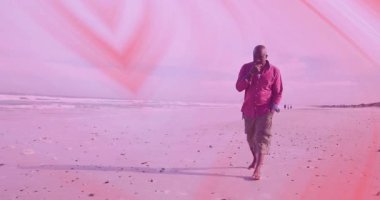 Sahilde yalın ayak yürüyen kıyı şeridinden yükselen animasyon finans grafiğini izleyen kıdemli bir adam. Dinginlik, tefekkür, rahatlık, kıyı, gündelik, doğal, sağIık