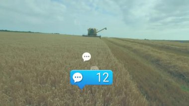 Hasat makinası altın buğday tarlasını kesiyor, beyaz sohbet simgeleri ve mavi uyarı 47 gösteriyor. Tarım, dijital iletişim, modern tarım, kırsal arazi, hasat, teknoloji, üretkenlik