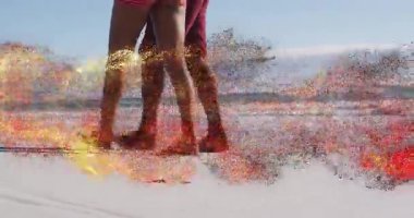 Kumlu sahilde çıplak ayakla yürüyen bir çift. Canlandırılmış adım sayacı ve kalp ikonu sağlığını gösteriyor. Sahil, sahil, eğlence, macera, açık hava, doğa, sağlık.