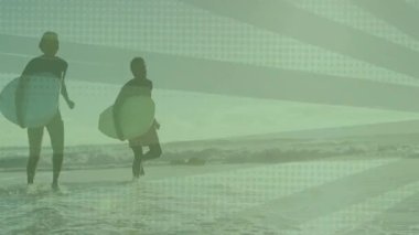 İki sörfçü sığ okyanus sularına girip sörf tahtalarının üzerinde animasyon teknolojisi veri tablosu sergiliyor. Macera, dostluk, spor, canlılık, kıyı şeridi, açık hava, dinamik