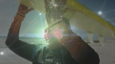 Kumsala bakan ufukta sarı sörf tahtası tutan adam. Parlayan teknoloji ağı. Macera, yenilik, bağlantı, canlılık, dinginlik, teknoloji, spor
