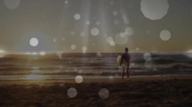 Gün batımında sahilde sörf tahtası tutan kıdemli bir adam. Bokeh fişekleri ile seyahat pazarlaması yapıyor. Yalnızlık, sükunet, emeklilik, farkındalık, rahatlık, ilham, sükunet