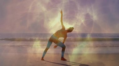 Kadın plajda yoga egzersizi yapıyor, kalp atış hızı grafiği ve sağlık simgeleri gösteriyor. Dinginlik, sağlık, farkındalık, fitness, doğa, açık hava, canlılık