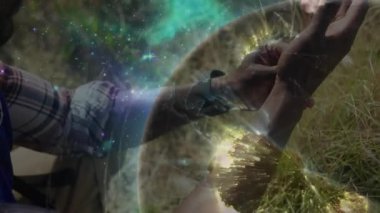 Diz çökmüş dua boncukları tutan, teknoloji için yıldızları ve küreyi barındıran bir adam. Ruhani, tefekkür, meditasyon, farkındalık, kozmik, açık hava, dinginlik