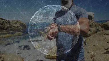 Kayalık sahilde akıllı seki ayarlayan adam, düğümlerle dijital ağ kürelerini gösteriyor. Teknoloji, bağlantı, fitness, açık hava, yenilik, modern iletişim