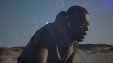 Erkek sporcu kumlu zemine eğilip spor teknolojisi için dijital çizgiler ve düğümler gösteriyor. Yalnızlık, dayanıklılık, esneklik, biyomekanik, dijital arayüz, fütüristik, açık hava