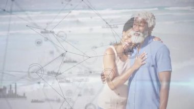 Kumsalda kafa üstü uzanan bir çift finans çizelgeleri ve ağ düğümleri sergiliyor. Romantik, bağlantı, yakınlık, sağIık, iletişim, açık hava, boş zaman